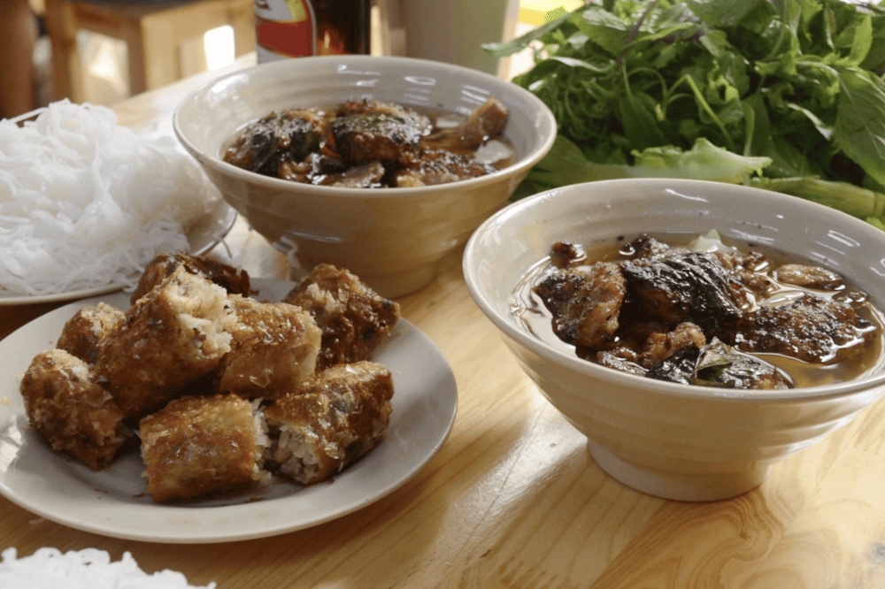 Bun cha brings together grilled pork, fresh herbs, and tangy broth in a dish that captures the soul of Hanoi cuisine (Source: Canva)