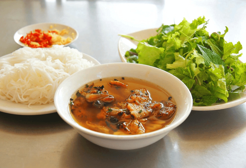 Bun Cha Hanoi consists of aromatic grilled pork, fresh vermicelli noodles, herbs, and a tangy-sweet dipping sauce (Source: Canva)