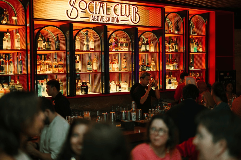 The glowing gold-lit bar invites guests to watch the finesse of skilled bartenders up close (Source: Social Club Rooftop Bar)