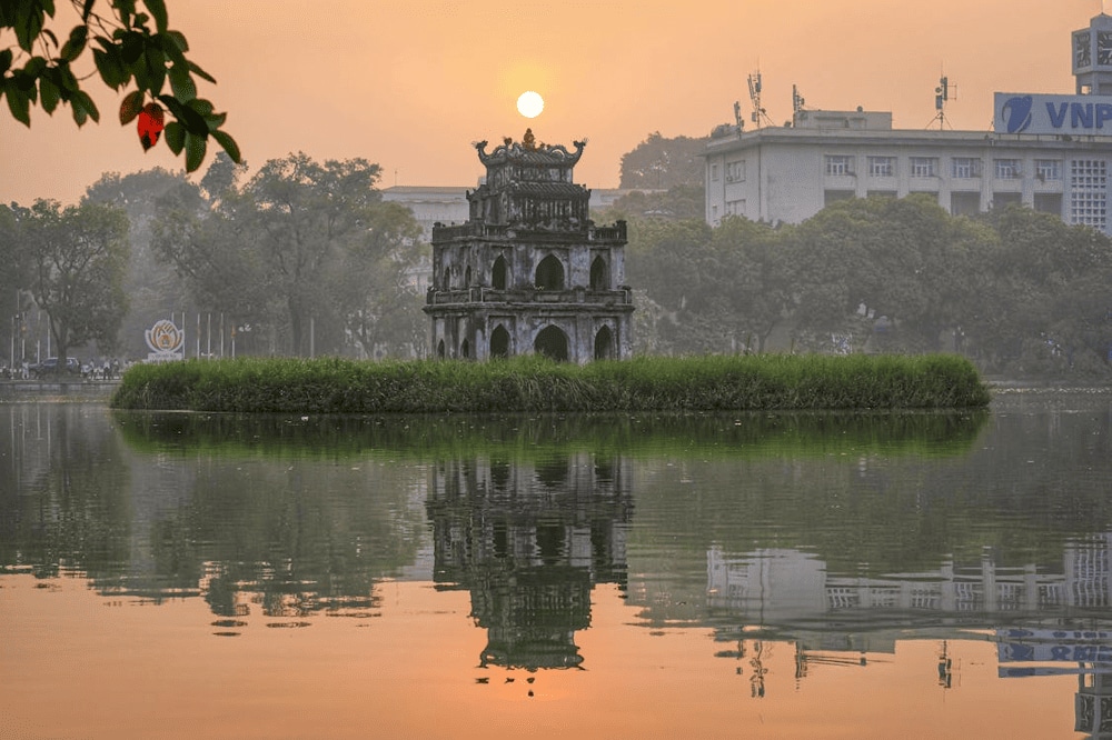 Morning in Hoan Kiem Lake awakens with golden reflections on tranquil water (Source: Pexels)