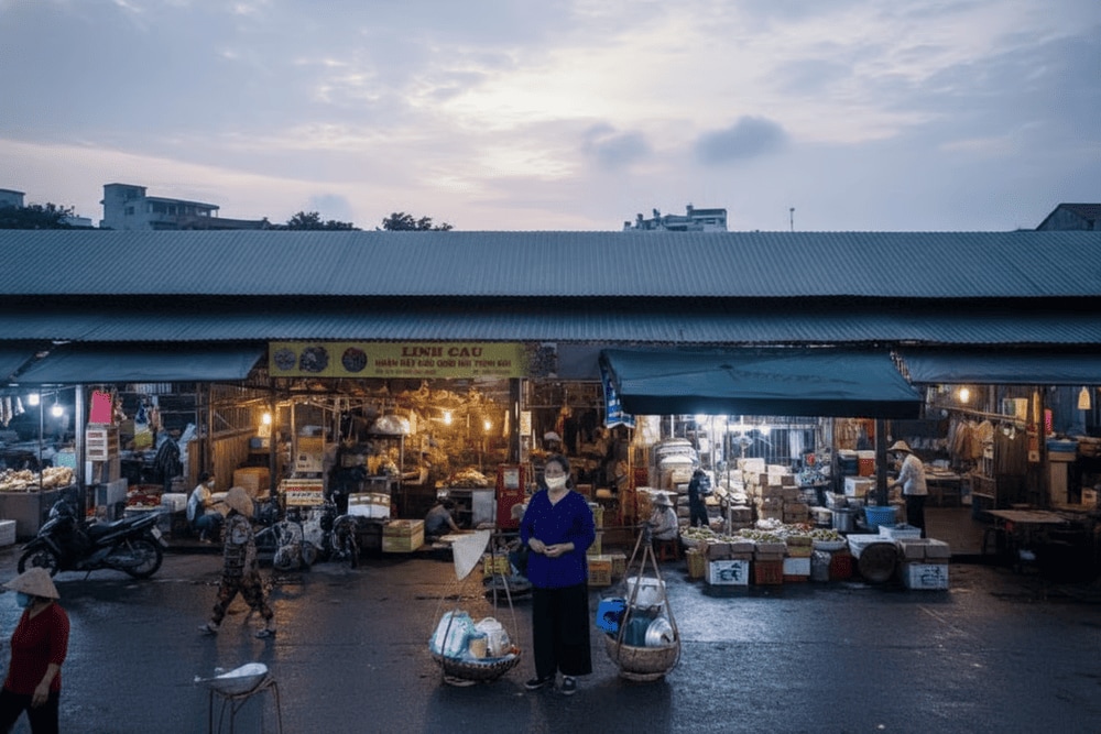 Một gánh hàng bán đồ ăn nhỏ nằm ngay bên cạnh sạp bán hoa và đồ khô tại chợ Long Biên (Nguồn: Internet)