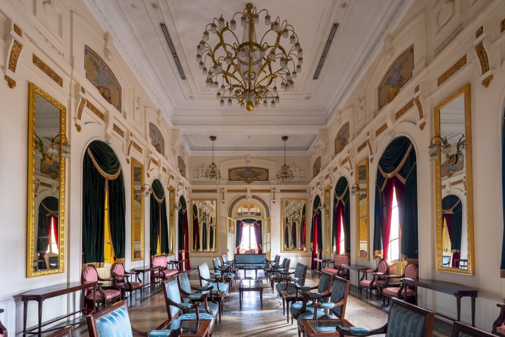 The Mirror Room, a lavishly decorated space with grand chandeliers and elegant mirrors