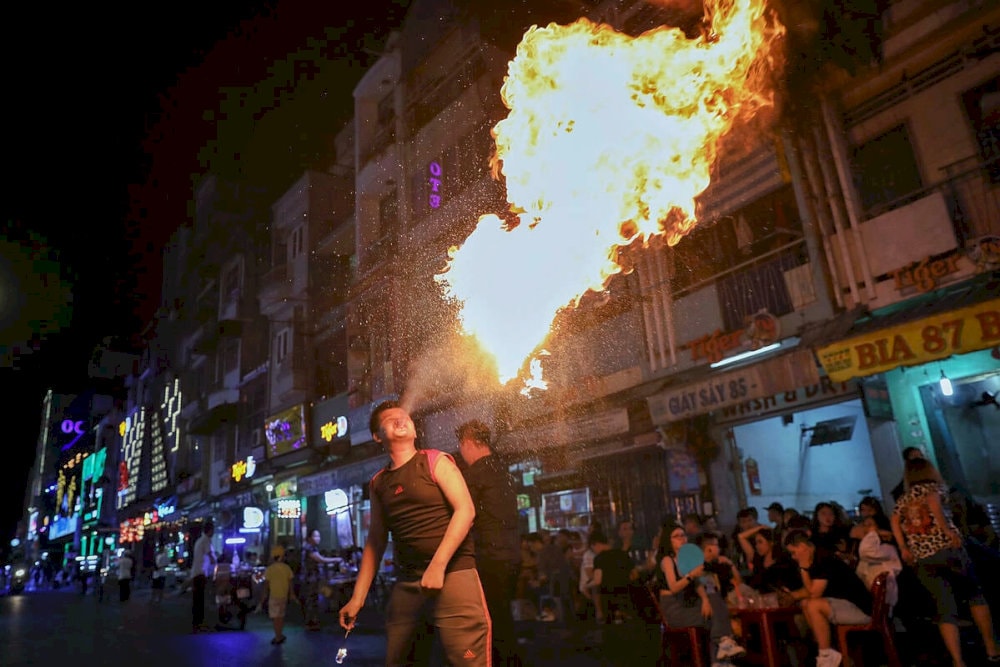 파이어 댄서와 거리 마술사가 Bui Vien (부이비엔)을 놀라운 무대로 바꾸는 스릴을 경험하십시오